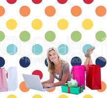 Composite image of happy blonde shopping online with laptop