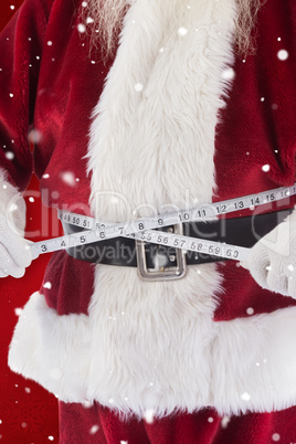 Composite image of santa claus measures his belly