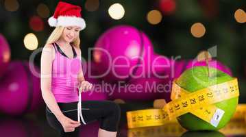 Composite image of fit festive young blonde measuring her thigh