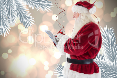 Composite image of santa uses a tablet pc