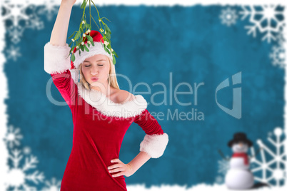 Composite image of festive cute blonde holding mistletoe