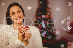 Composite image of pretty brunette relaxing on sofa at christmas