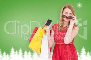 Composite image of cute woman holding shopping bags and her smar