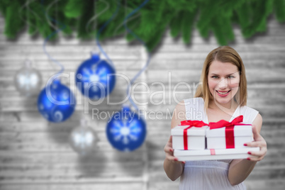 Composite image of woman holding presents