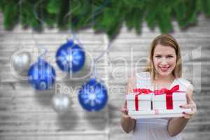 Composite image of woman holding presents