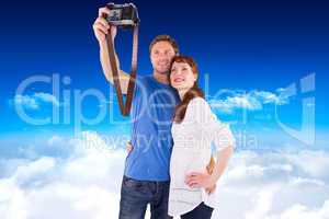 Composite image of couple using camera for picture