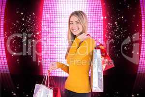 Composite image of stylish blonde smiling with shopping bags