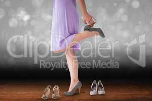 Composite image of mid section of woman trying heels