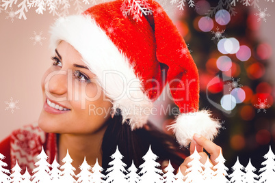 Composite image of festive brunette wearing a santa hat