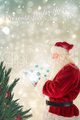 Composite image of santa uses a tablet pc