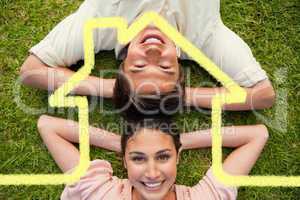 Composite image of two friends smiling while lying head to head