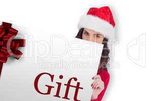 Composite image of beauty brunette in santa hat showing gift car