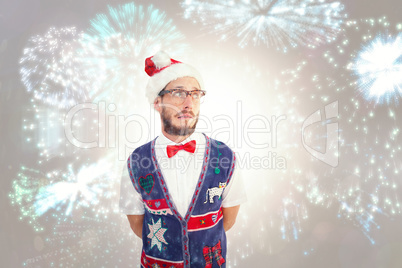 Composite image of geeky hipster in santa hat