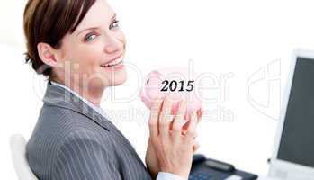 Composite image of cheerful businesswoman holding a piggybank