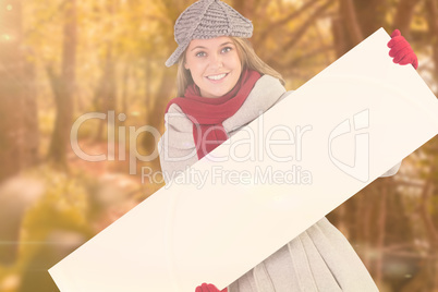 Composite image of happy blonde in winter clothes showing card