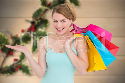 Composite image of smiling woman presenting while holding shoppi