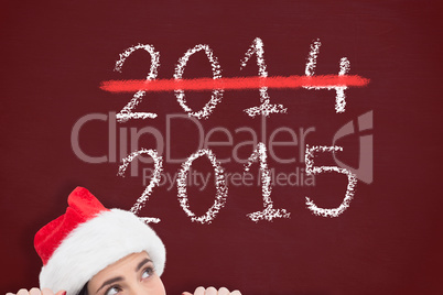 Composite image of pretty brunette in santa hat showing white po