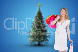 Composite image of happy blonde holding shopping bags in white d