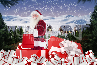 Composite image of santa standing in large gift