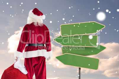 Composite image of santa carrying sack of gifts