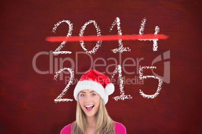 Composite image of festive blonde holding large poster