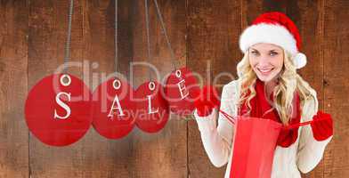 Composite image of happy festive blonde with shopping bag