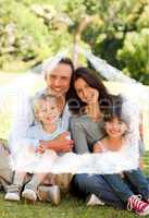 Composite image of family sitting in the park