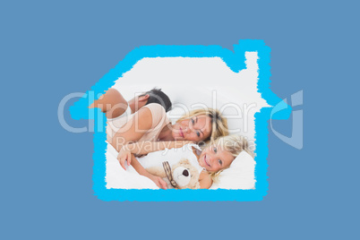 Composite image of family lying together on a bed