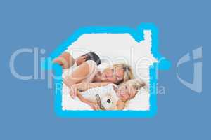 Composite image of family lying together on a bed