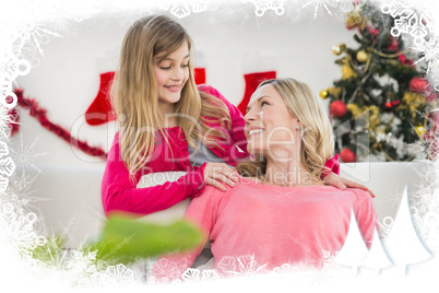 Composite image of festive mother and daughter on the couch