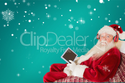 Composite image of father christmas listening to music with tabl