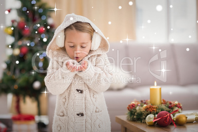 Composite image of festive little girl blowing over hands