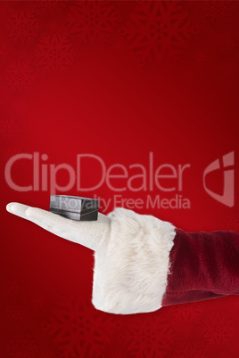 Composite image of santas hand shows a small box