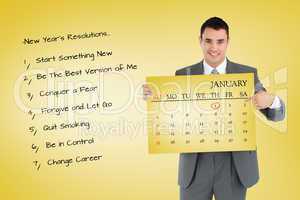 Composite image of businessman pointing at calendar he is holdin