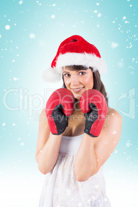 Composite image of festive brunette with boxing gloves