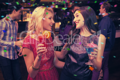 Composite image of pretty friends drinking a cocktail