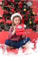 Composite image of festive little girl opening a gift