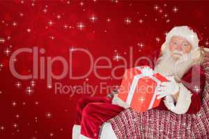 Composite image of father christmas offering a red gift