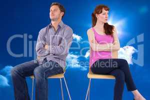 Composite image of sitting couple ignoring each other