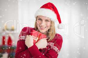 Composite image of festive pretty woman hugging her gift