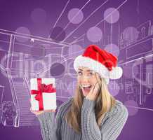 Composite image of festive blonde holding christmas gift