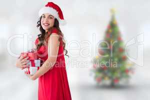 Composite image of festive brunette holding pile of presents