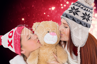 Composite image of mother and daughter kissing teddy