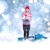 Composite image of festive blonde holding pile of gifts