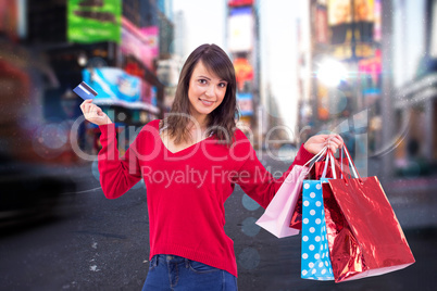 Composite image of brunette holding gift and credit card
