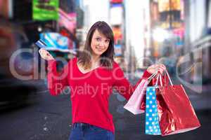 Composite image of brunette holding gift and credit card