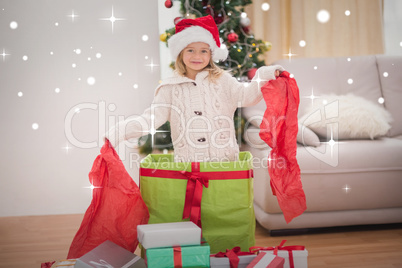 Composite image of cute little girl sitting in giant christmas g