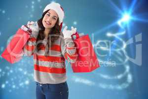 Composite image of cheerful brunette holding shopping bags full