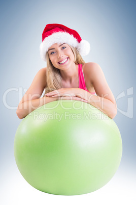 Festive fit blonde posing with exercise ball