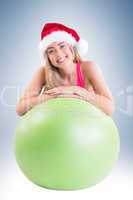 Festive fit blonde posing with exercise ball